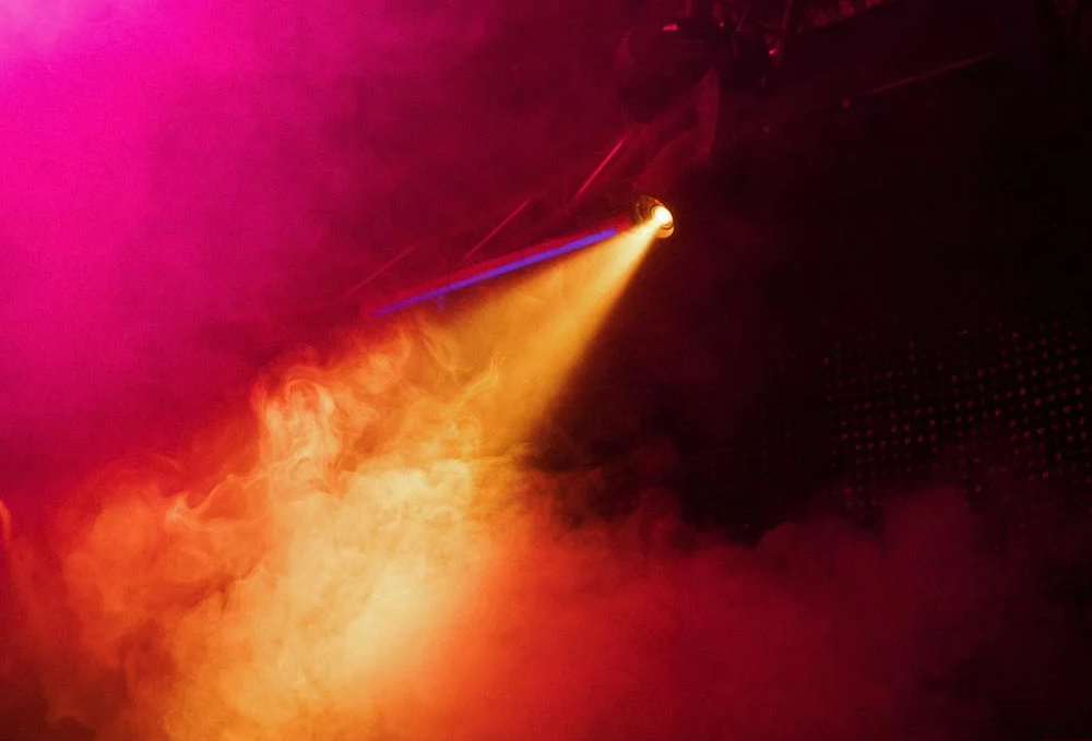 Smoke machine reflecting orange and pink lights